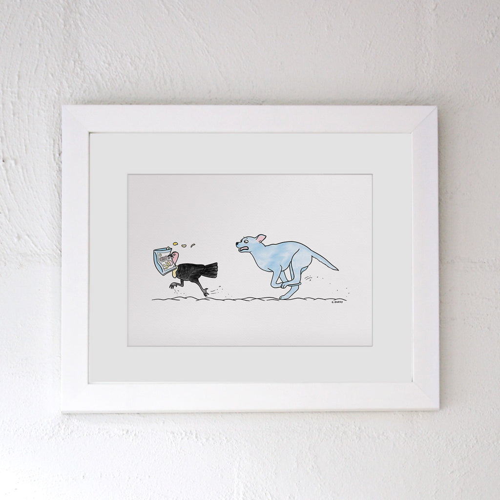 White framed Hound Town artwork on a white wall featuring a digital illustration of a pastel blue staffy type dog chasing a bush turkey which has stolen a bag of chips