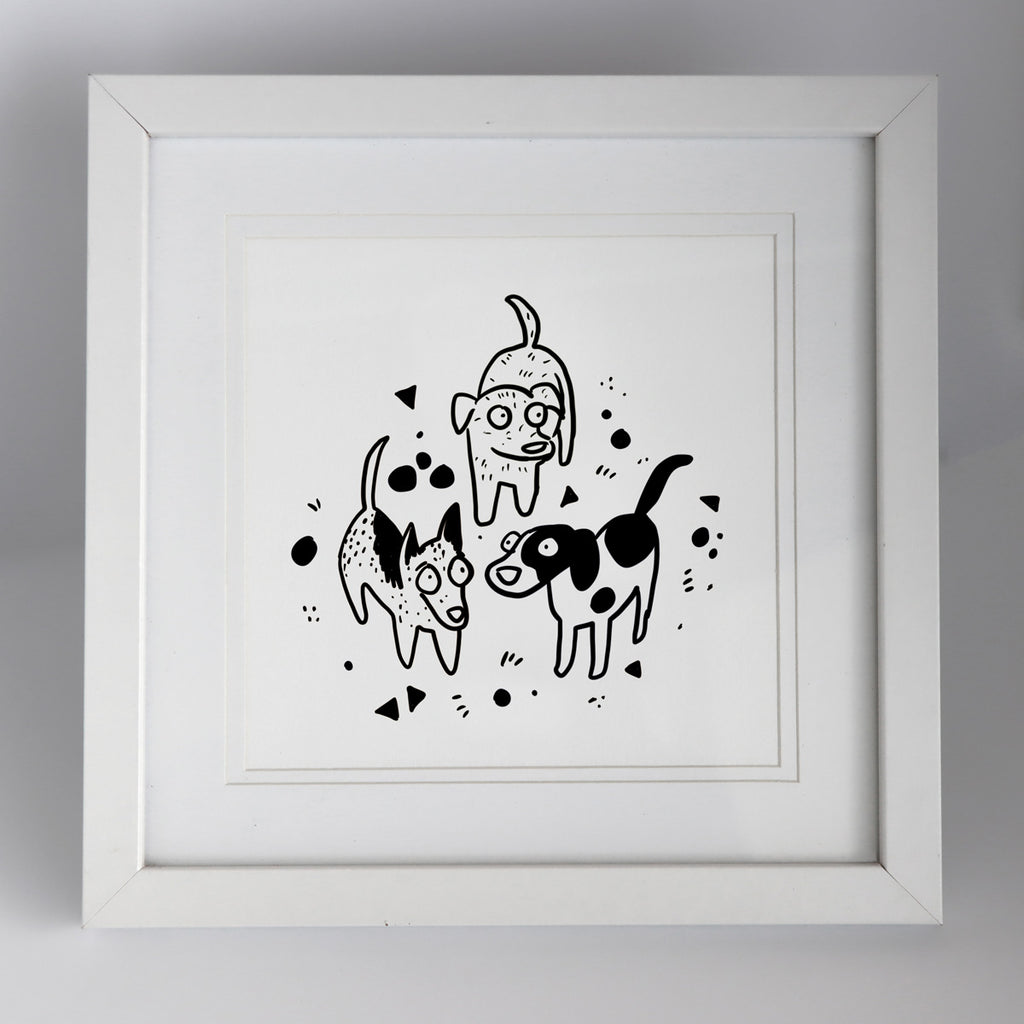 A Hound Town artwork of three cartoon style black and white dogs standing amongst triangle and circle patterns inside a square white frame by Clare Duffy