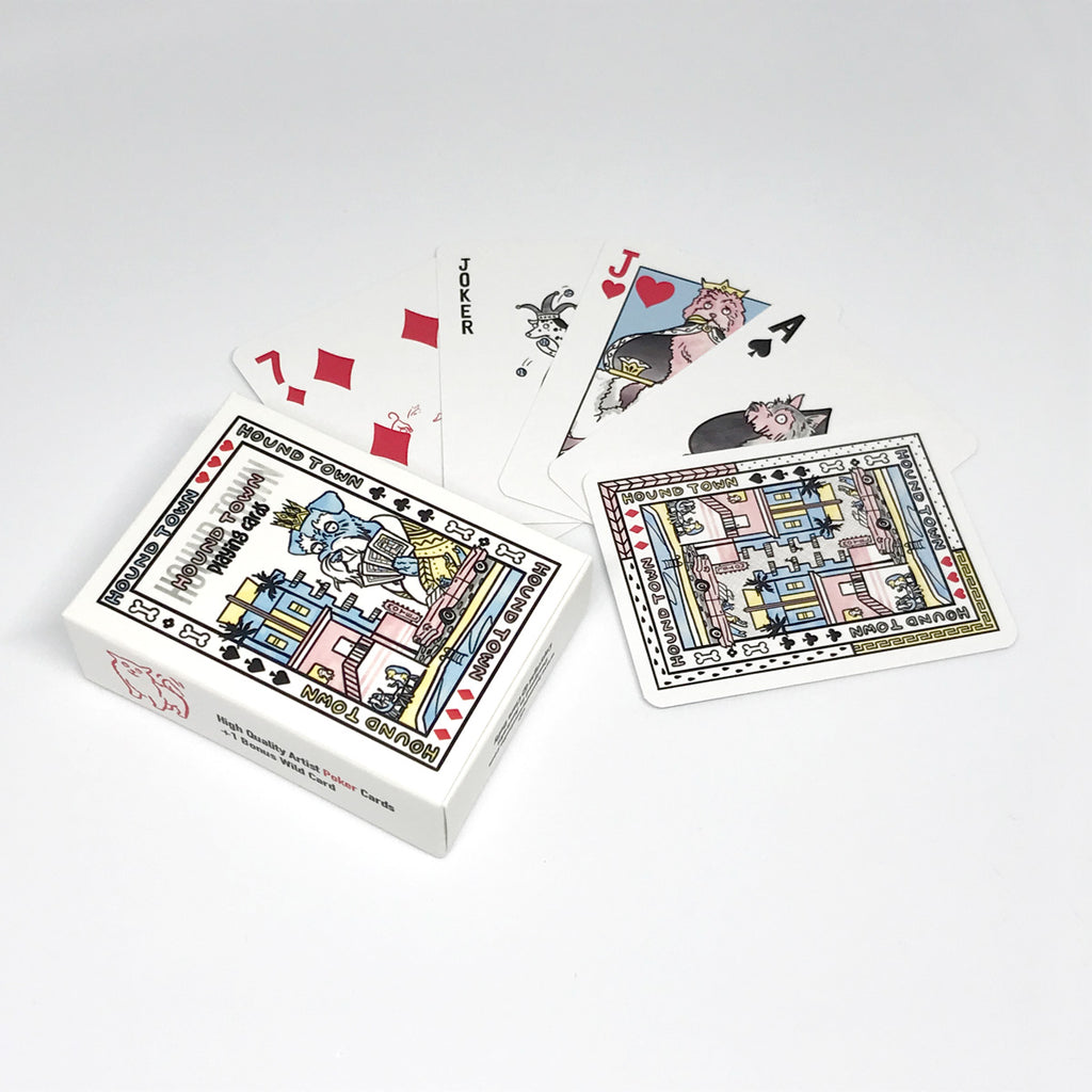 Hound Town illustrated playing cards showing the box on the left and a sample of the cards splayed out including the 7 of diamonds with a dog digging, a joker - a dalmatian, Jack of hearts the cavoodle and Ace of clubs the yorkshire terrier.