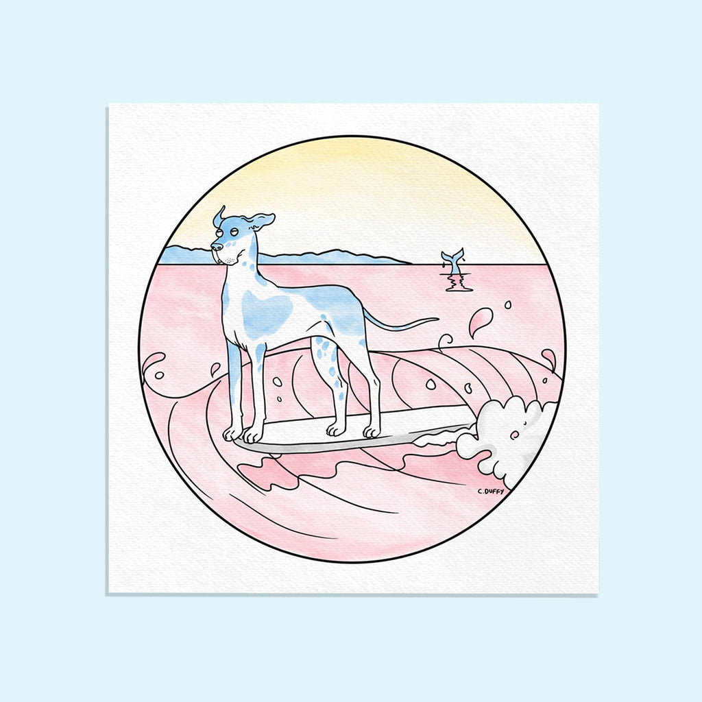 A Hound Town fine art print on a light blue background featuring a great dane with blue patches surfing and hanging ten on a pink wave inside a circle and a whale tail in the distance as well as a blue headland and a yellow sunset sky - artwork by Clare Duffy